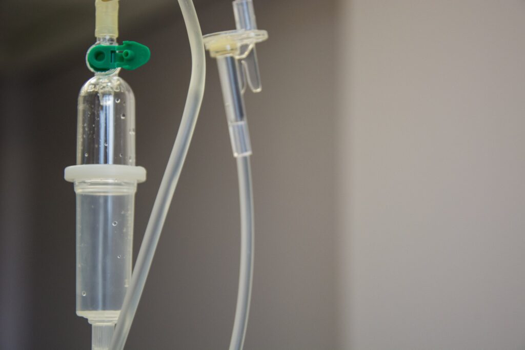 A close-up view of an IV drip line with clear tubing and a drip chamber.