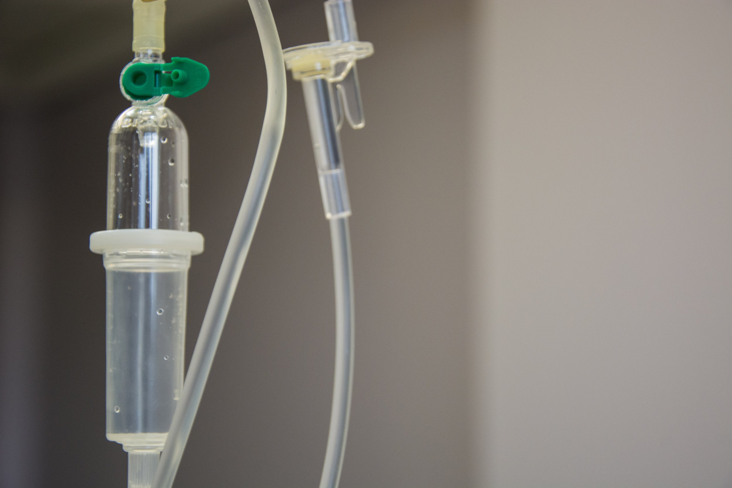 A close-up view of an IV drip line with clear tubing and a drip chamber.