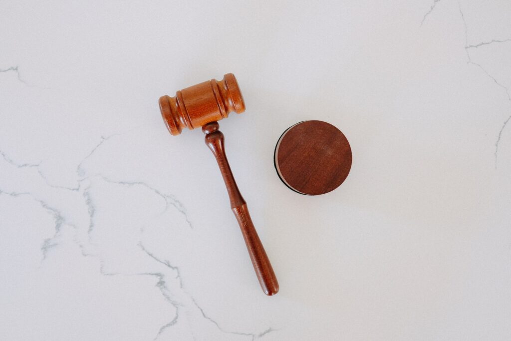 A wooden gavel and a circular base on a marble surface.